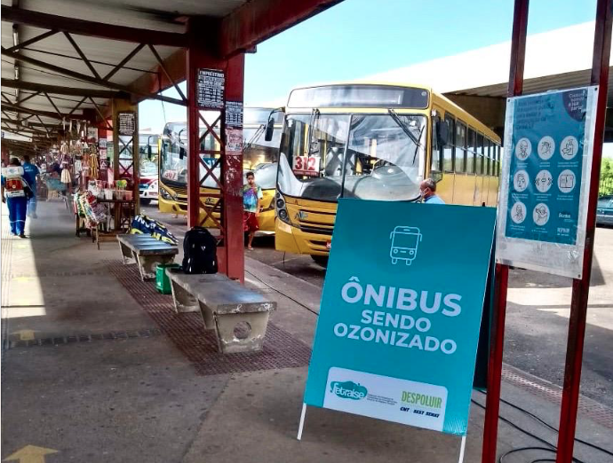 Parte coberta de terminal de integração com cavalete "ônibus sendo ozonizado"